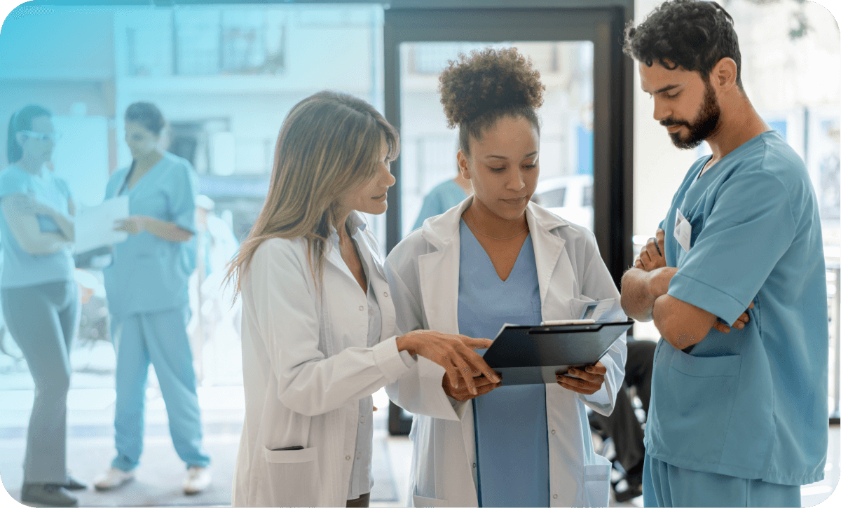 Three healthcare professionals discuss a file